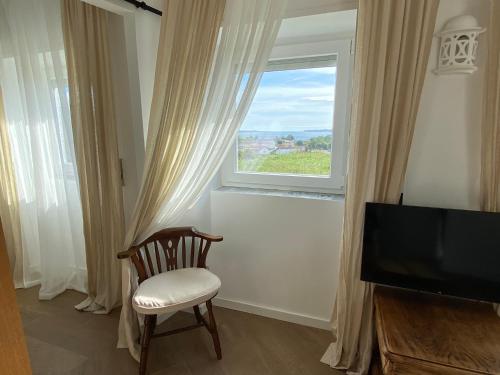 een woonkamer met een stoel en een raam bij Casa do Montinho in Caminha