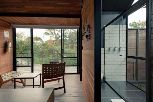 a room with a chair and a table and a glass door at The Boato Hotel in Guatapé