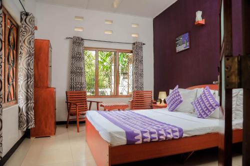 a bedroom with a bed and a table and chairs at Destine Holiday Bungalow in Galle