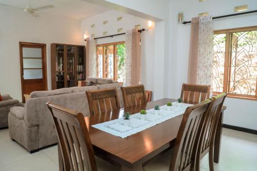 a living room with a wooden table and chairs at Destine Holiday Bungalow in Galle
