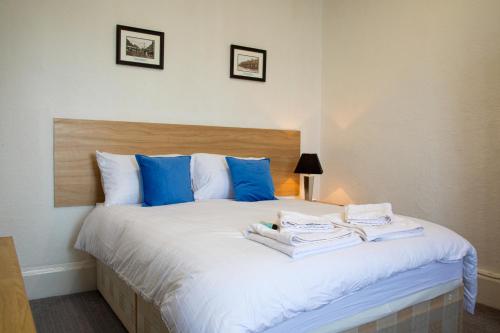 a bedroom with a bed with blue and white pillows at The Highlands, Bispham in Blackpool