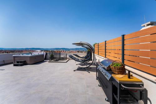 a patio with a grill on a roof at Luxury Penthouse ARIA in Zadar