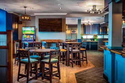 a kitchen with wooden tables and chairs in a room at The Highlands, Bispham in Blackpool