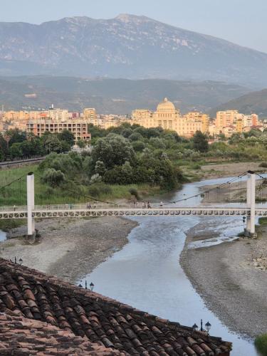 a bridge over a river with a city in the background at Timo's Guest House in Berat