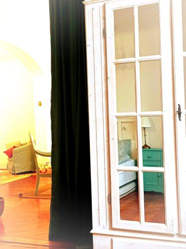 a large white cabinet with glass doors in a room at Mályva-ház Verőce in Verőce
