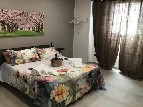 a bedroom with a bed with a flowery comforter at B&B anna leverano in Leverano