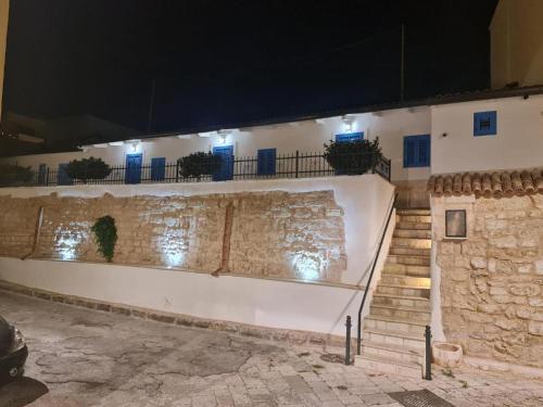 a white building with stairs and blue lights at Le Casette in Brindisi