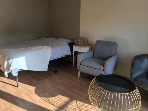 une petite chambre avec un lit et une chaise dans l'établissement Welcome Home Parking, terrasse, à Châteauroux