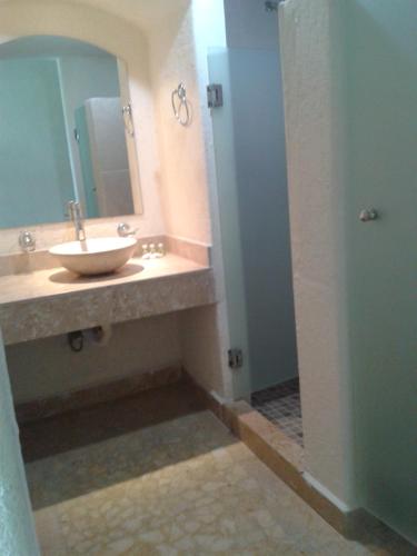 a bathroom with a sink and a mirror and a shower at Hotel RRU Diamante in Acapulco