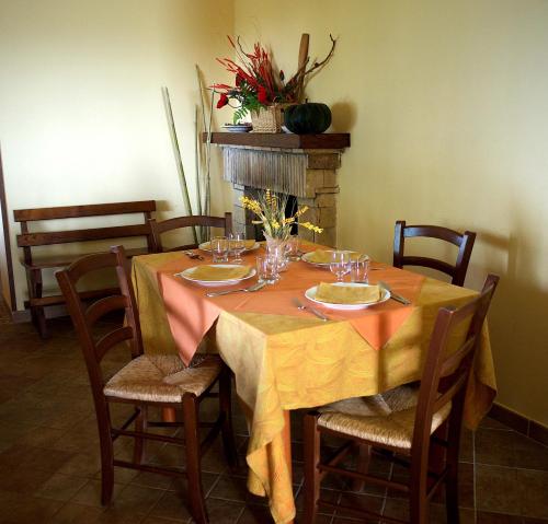 a dining room table with a yellow table cloth and chairs at La Staccionata in Arpino