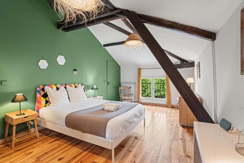 - une chambre avec un grand lit et des murs verts dans l'établissement La maison Léon, à Lesperon