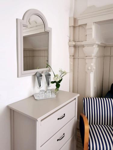 a white dresser with a mirror and a chair at Villa Streintz in Millstatt