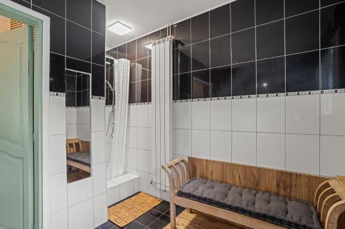 un banc dans une pièce avec du carrelage noir et blanc dans l'établissement La maison Léon, à Lesperon