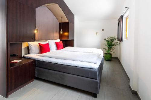 a bedroom with a large bed with red pillows at Naturchalets 7 Sentidos in Bischofsmais