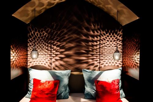 a bedroom with a headboard with red pillows at Naturchalets 7 Sentidos in Bischofsmais