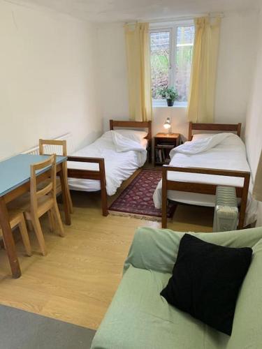 a living room with two beds and a table at Sleeping Giant outdoor adventure flat in Pen-y-cae
