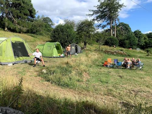 a group of people in a field with tents at Sleeping Giant outdoor adventure flat in Pen-y-cae