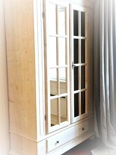 a wooden cabinet with a window in a room at Mályva-ház Verőce in Verőce