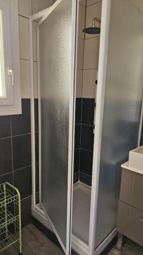 une douche avec une porte vitrée dans une salle de bain dans l'établissement Agréable et familiale T2 Canet Plage, à Canet