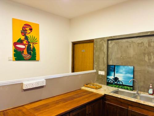 a kitchen with a sink and a painting on the wall at Havelock City Hostel, Colombo in Colombo