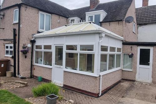 a conservatory with a roof on a house at 'rose cottage' a 19th century cottage in Findern in Findern