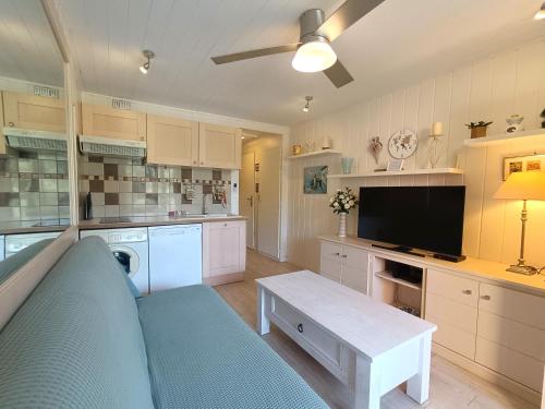 Il comprend une grande cuisine avec un canapé et une télévision. dans l'établissement T3 Piscine Plage Parking, à Six-Fours-les-Plages