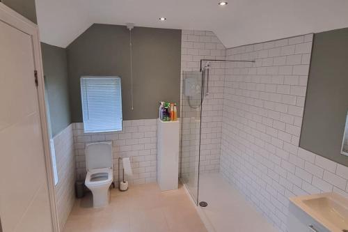 a bathroom with a shower and a toilet at 'rose cottage' a 19th century cottage in Findern in Findern