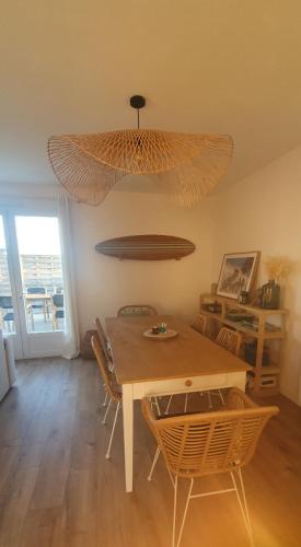 une salle à manger avec une table et un grand éclairage dans l'établissement Maison au calme proche de l'océan et du golf, à Talmont-Saint-Hilaire