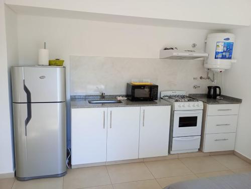 a kitchen with a refrigerator and a stove at Monoambientes MOKA in Concepción del Uruguay