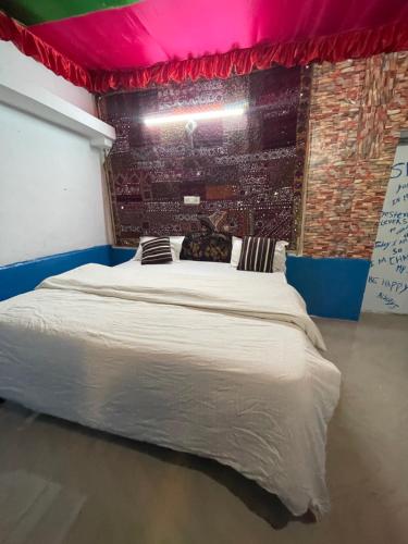 a large bed in a room with a pink ceiling at Mirvana Guest House & Camel safari in Jaisalmer