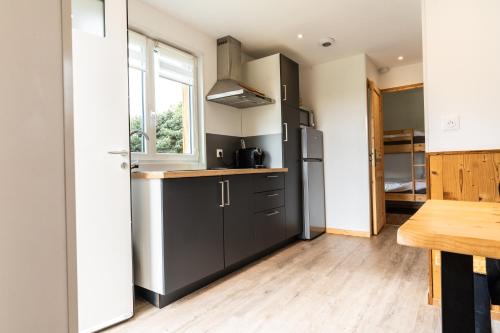 a kitchen with a stainless steel refrigerator and a table at Chais de L'Epinay in Le Bignon
