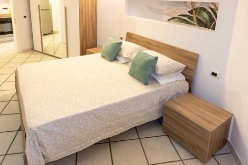 a bedroom with a bed with green pillows at Dream Garden in Scafati