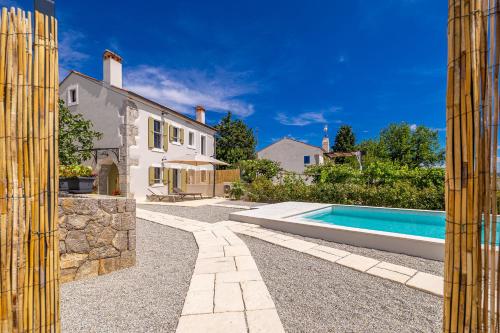 an external view of a house and a swimming pool at Holiday house Rural home Frane in Kornić