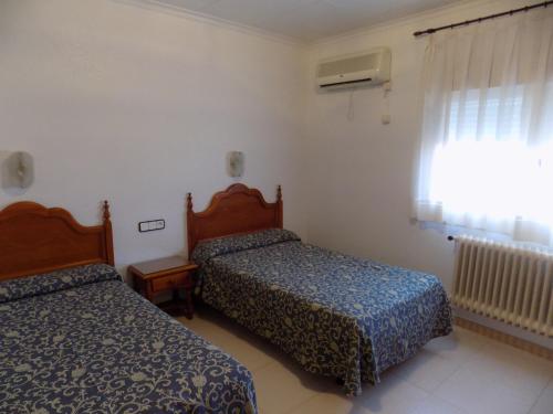 Cette chambre comprend 2 lits et une fenêtre. dans l'établissement Hostal Amigo, à Ocaña