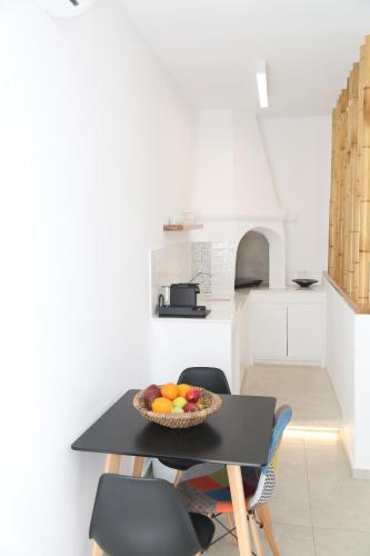 a kitchen with a table with a bowl of fruit on it at Anais in Mýkonos City