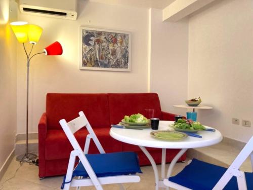 - un salon avec un canapé rouge, une table et des chaises dans l'établissement Apartment in Theoule sur mer village, à Théoule-sur-Mer