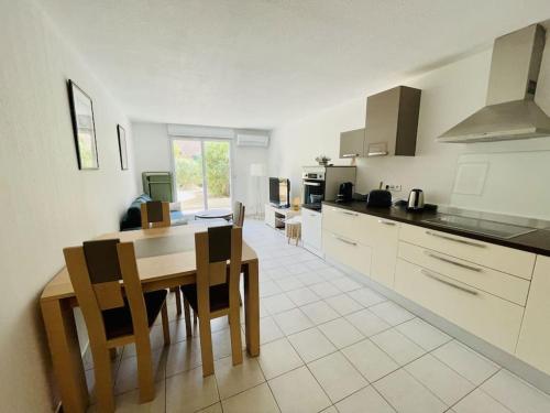 a kitchen with a table and chairs in a kitchen at Appartement, 1 chambre, jardin privatif in Venelles