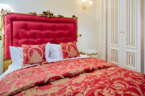 a red bed with a red headboard in a bedroom at Maison des Barons in Nice