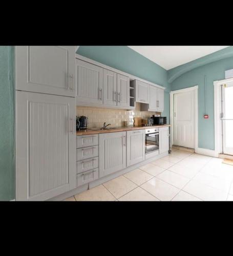 a large kitchen with white cabinets and a window at 4bed Townhouse in heart of Sligo in Sligo