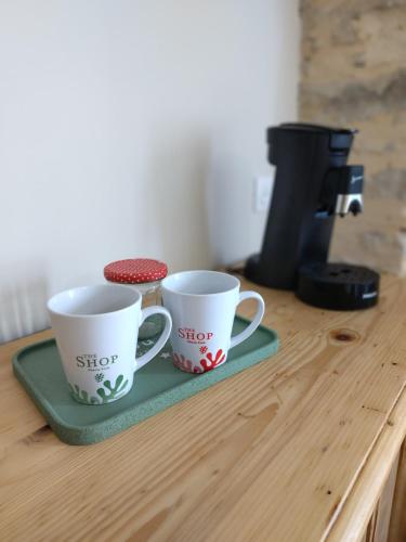 deux tasses à café posées sur un comptoir en bois dans l'établissement Chez Miss Gwen, à Montagnac