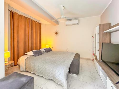 a bedroom with a bed and a flat screen tv at Studio Vesna with a terrace and sea view in Rabac