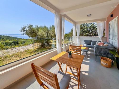 a living room with a table and chairs and a large window at Studio Vesna with a terrace and sea view in Rabac