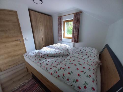 a bedroom with a bed with a comforter and a window at Ferienwohnung Feichter in Gersdorf