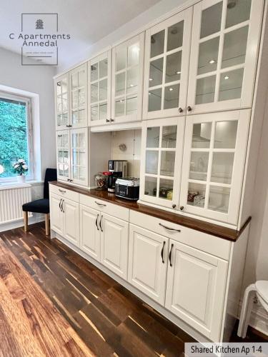 a kitchen with white cabinets and a counter at C Apartments Annedal in Gothenburg
