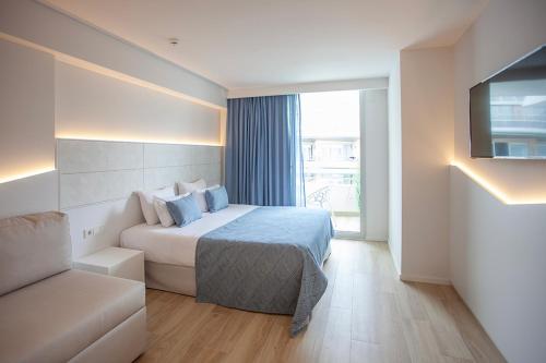 a hotel room with a bed and a couch at Hotel Montemar Maritim in Santa Susanna