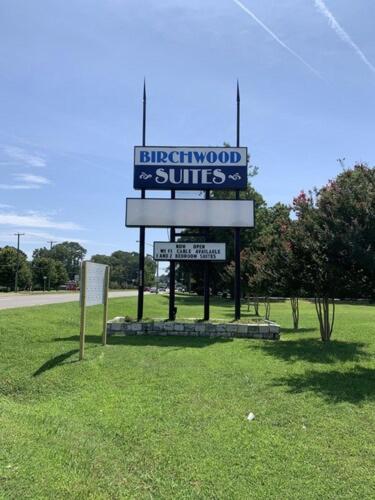 a sign in the middle of a grass field at Paradise Suites - Newport News & Jefferson Ave in Newport News