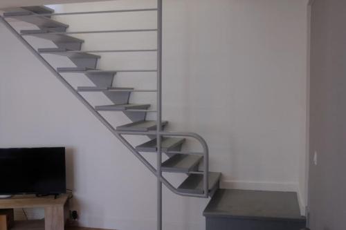 un escalier avec une télévision dans une pièce dans l'établissement R'Apparts T2 Duplex Urbain, à Grenoble