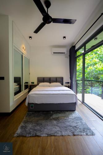 a bedroom with a bed and a ceiling fan at Forest Face Lodge in Gurudeniya
