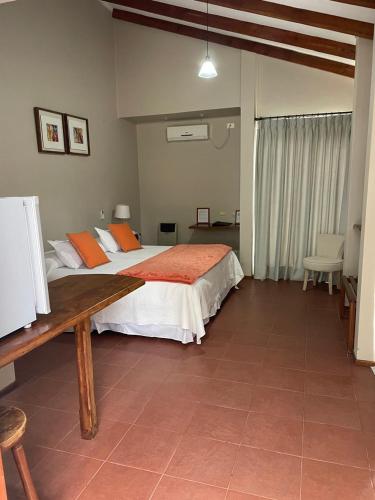 a bedroom with a large bed with orange pillows at Hotel Altos de Tuqui in Ovalle