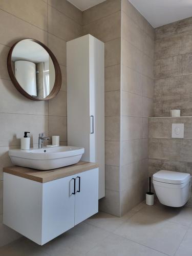 a bathroom with a white sink and a mirror at Apartment Nikolaj in Labin